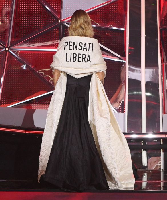 <p>Dress code: autodeterminazione. Chiara Ferragni si affaccia per la prima volta sulla scalinata dell’Ariston girata di spalle, coperta da una stola damascata con su scritto: “<strong>PENSATI LIBERA</strong>”. Una <em>mise </em>che non può non ricordare l’abito <em>Tax the Rich</em> sfoggiato da <strong>Alexandra Ocasio Cortez</strong> al Met Gala nel 2021. Il messaggio nasce da una conversazione tra Chiara, Maria Grazia Chiuri (direttore artistico di Dior) e l’artista concettuale <strong>Fulvia Carnevale</strong> del duo artistico Claire Fontaine. «“<em>Pensati libera” è dedicato a tutte le donne che hanno voglia di sentirsi semplicemente loro stesse senza essere giudicate</em>», ha spiegato Ferragni su Instagram.</p>
