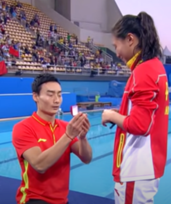 <p>Facciamo un salto temporale di 5 anni: siamo alle Olimpiadi del 2016 di Rio e l’atleta cinese He Zi vince la finale di trampolino da 3 metri, mentre Tania Cagnotto si aggiudica l’argento. Il tuffatore Qin Kai festeggia insieme a lei inginocchiandosi e chiedendole di sposarlo con tanto di anello.</p>
